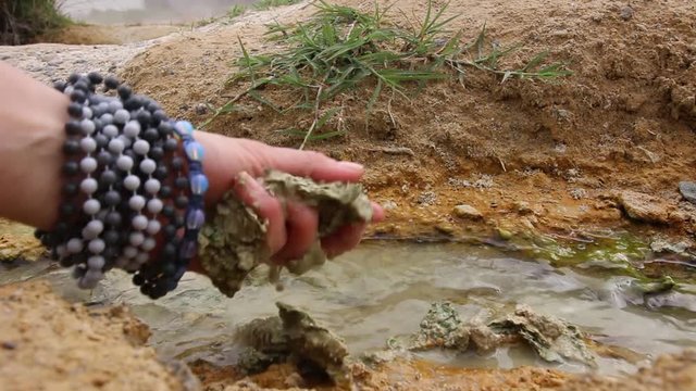 Hand taking healing mud. Thermal spring Rupite, Bulgaria. HD video.