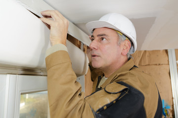 man worker adjusting blinds molding