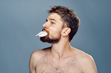 a man with a beard in his mouth keeps wadded disks n alice cream to care for a lot of face skin on...