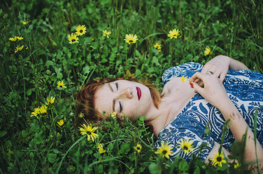 Young woman sitting in field of flowers