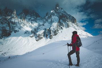 Naklejka na ściany i meble Young female hiker admires the beauty of nature in winter