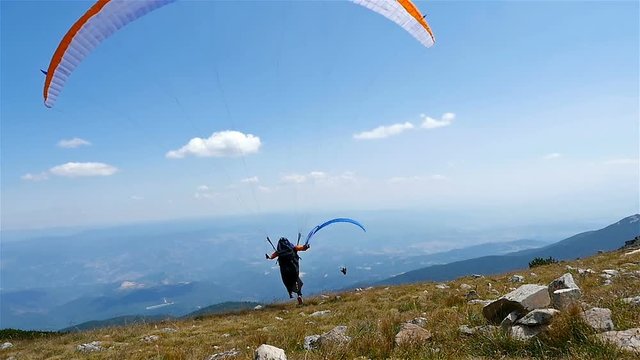 Paragliders fly over amazing mountain, slow motion