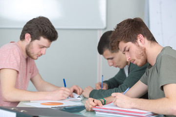 3 male young students studying together