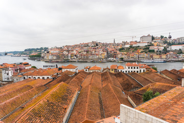 Fototapeta na wymiar View on Vila Nova de Gaia on Douro river in Porto, Portugal. British wine and port cellars - popular touristic attraction and destination for wine and port tasting with tours and excursions.