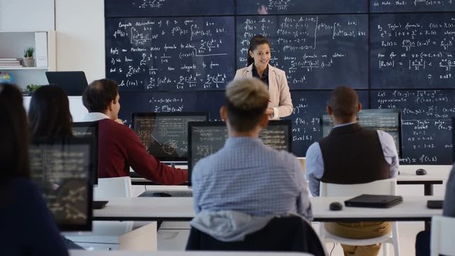  Teacher in adult education class explaining math formulas to students
