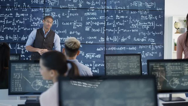  Teacher in adult education class explaining math formulas to students