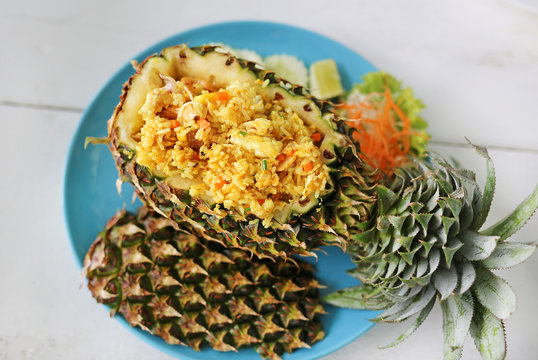 Prepared pineapple fried rice served inside of a pineapple carved like a bowl. Top view.