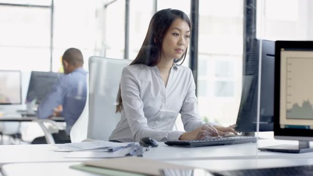  Pensive businesswoman in the office looking out of window, deep in thought