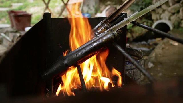 Traditional rice dish prepared on open fire in bamboo boles in Longsheng, Guanxi County, China.