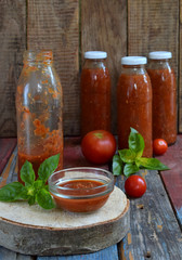 Jars of tomato sauce with chili, pepper and basil. Bolognese sauce, passata, lecho or adjika. Preservation. Canning.