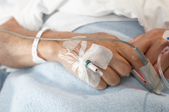 Close up of pacient's hands with health care devices