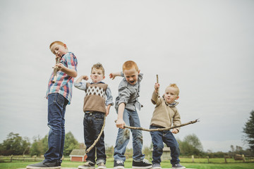 four brothers goofing around with sticks