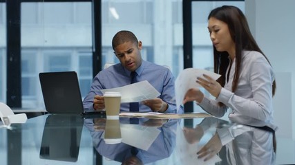 Business man and woman in a meeting looking over the company figures