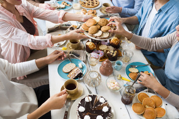Guests by festive table helping themselves with fresh homemade pastry