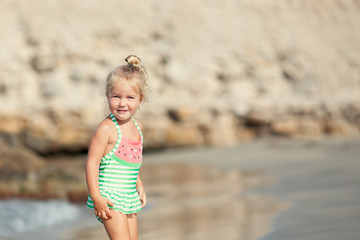 Little cute happy girl bathes in sea,