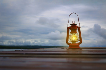 Burning lantern on a dock at a lake in the twilight © Alaskajade
