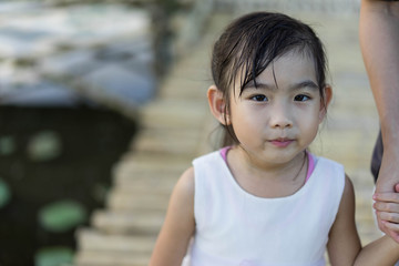 Asian cute little girl White dress Mother Shake hands Walking