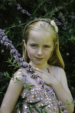 A little girl in a sequinned dress surrounded by flowers