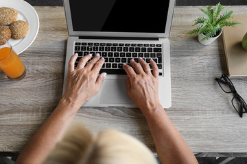 Fototapeta premium Mature woman using laptop indoors