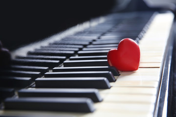 Red heart on piano keys, closeup
