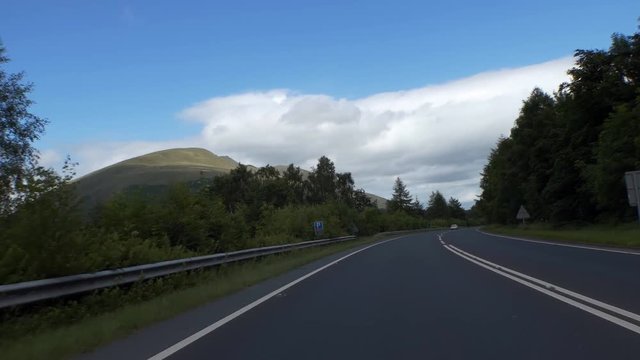 Car front passenger point of view when driving through beautiful scenery of English Lake District, England, United Kingdom, handheld camera