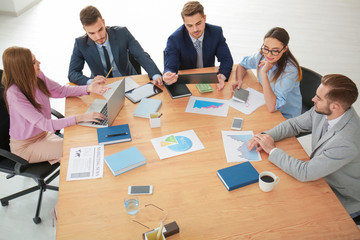 Team of young managers discussing project in office © Africa Studio