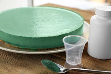 Plate with tasty spirulina cheesecake on table