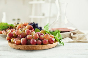 Plate with fresh ripe grapes on table