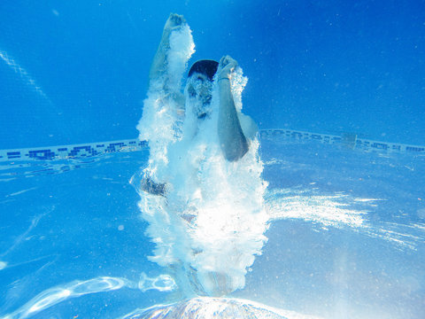Rotated photo of man jumping into a pool