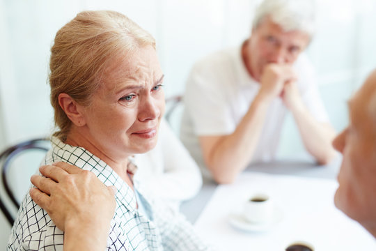 Helpful Man Reassuring Crying Friend During Discussion Of Problems