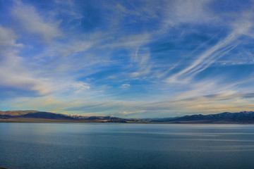 sky with huge grey clouds over sea surface at sunset 

