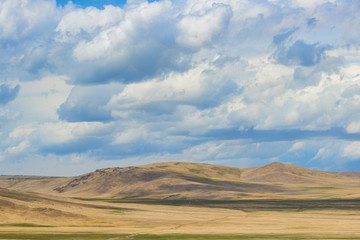 Fototapeta premium Panoramic view of green plain with hills at sunny day 