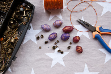 Assembly of jewelry of polymer clay in bohemian style with gold elements and box with small beads....