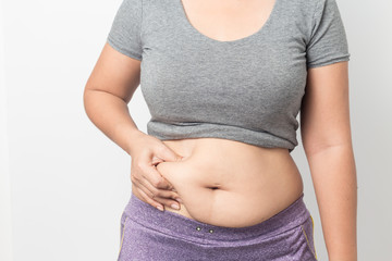 Overweight woman hand pinching excessive belly fat on gray background, Healthy concept
