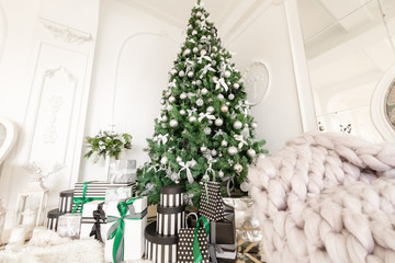 Christmas morning. classic apartments with a white fireplace, decorated tree, bright sofa, large windows