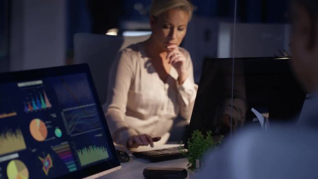 Businesswoman working late at the office with male colleague