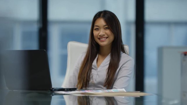  Portrait smiling businesswoman working on laptop at her desk