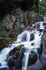 Obraz premium long exposure photo of a small waterfall falling down the stream