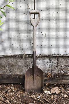 Rusty spades before a compost sieve in a garden