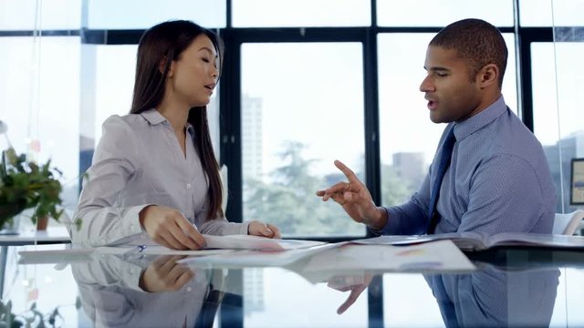  Business manager reprimanding female member of staff in office meeting