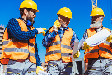 Three workers in uniform at construction site