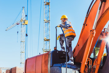 Construction worker on top of excavator cabin © LIGHTFIELD STUDIOS