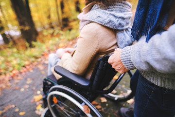 Obraz premium Senior couple with wheelchair in autumn forest.