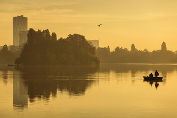 Fototapeta premium Fishermen fishing on a lake at sunrise