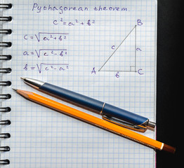 Page with formulas and the Pythagorean theorem with pen and pencil