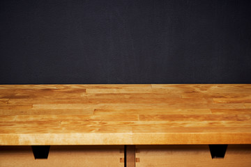 bright wooden shelf on a black writing wall                       