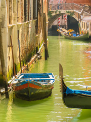 Fototapeta na wymiar Venetian channel with ancient houses, the bridge, boats and gondolas