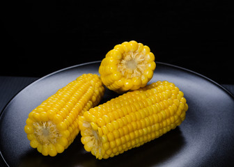 sweet boiled corn on a black plate
