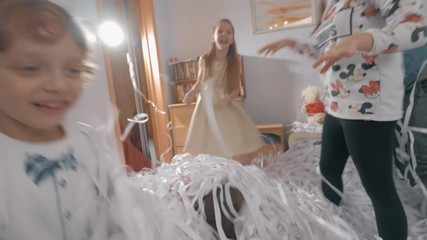MOSCOW, RUSSIA -MARCH 03, 2017: Kids (with model release) playing and fighting with paper confetti. Paper party for children at home