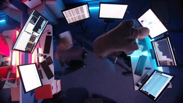  Time lapse businessmen surrounded by computer screens in dark room